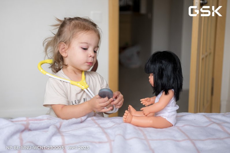 Une fille examine une poupée avec un stéthoscope jouet Une fille examine une poupée avec un stéthoscope jouet